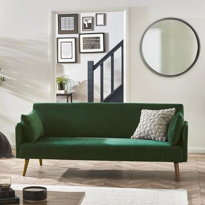 Green sofa bed in a living room with a mirror and framed pictures on the wall.