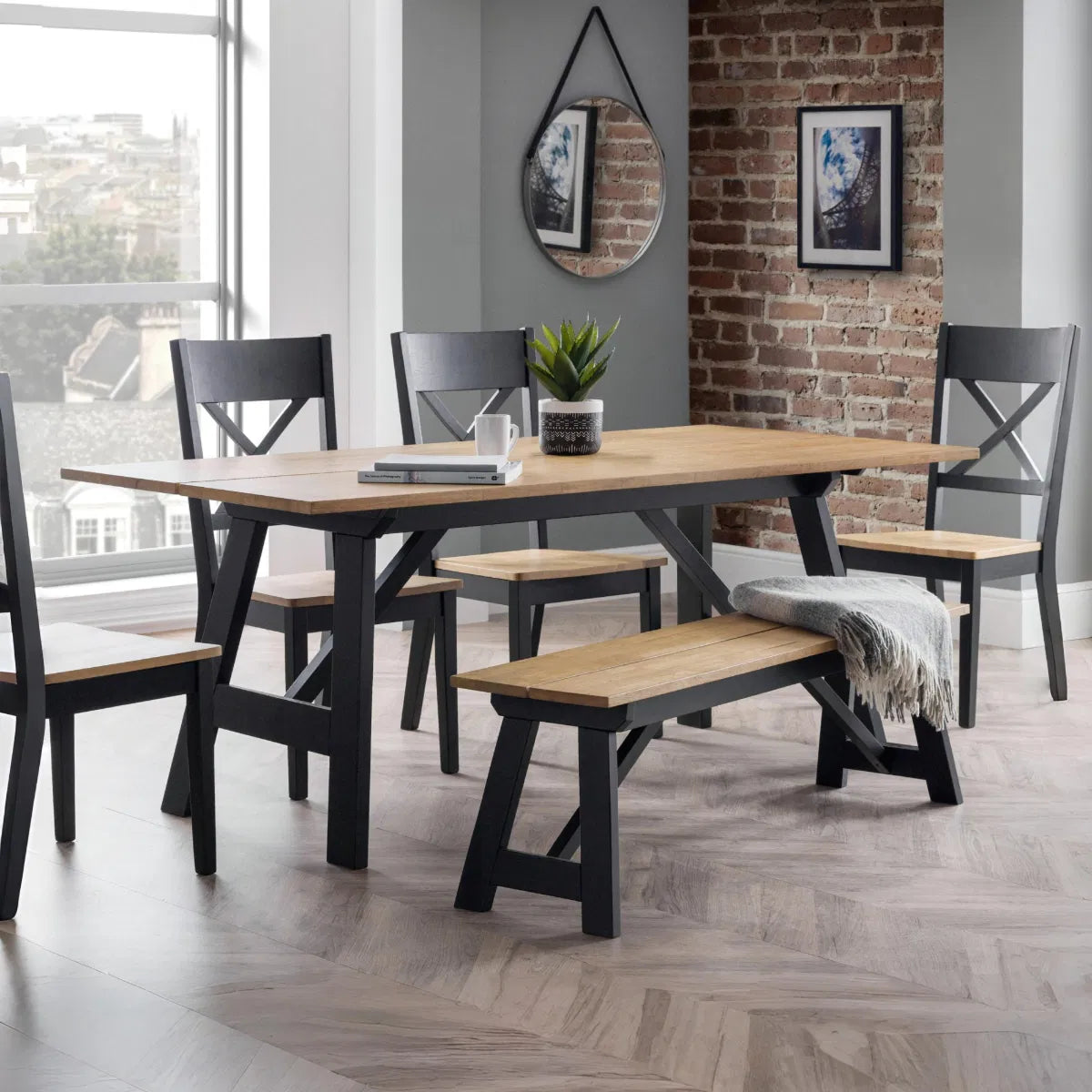 Dining room with a wooden table and chairs against a brick wall.