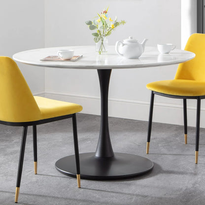 Round dining table with yellow chairs in a modern interior setting