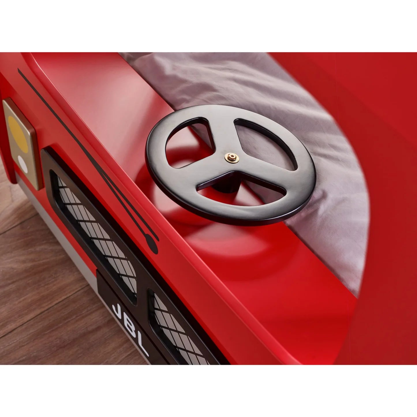Red toy car with a black steering wheel on a wooden floor
