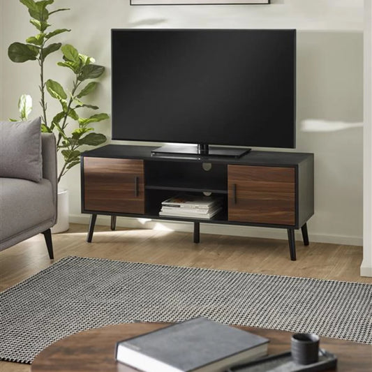 Modern living room with a TV on a wooden stand, gray sofa, and decorative items.