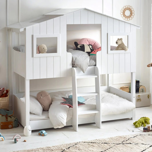 White children's bunk bed with toys and bedding in a bright room.